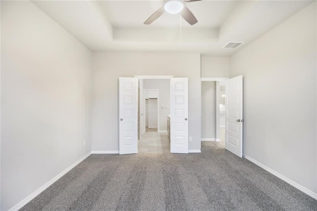 828 Laguna Green Ln, Katy, TX 77493 - unfurnished bedroom with a tray ceiling, carpet flooring, and ceiling fan