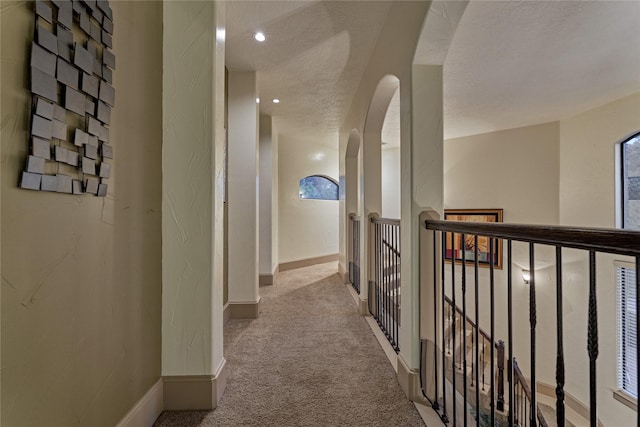 3 Creekwood Dr, Montgomery, TX 77356 - hall with carpet, arched walkways, an upstairs landing, and a textured ceiling