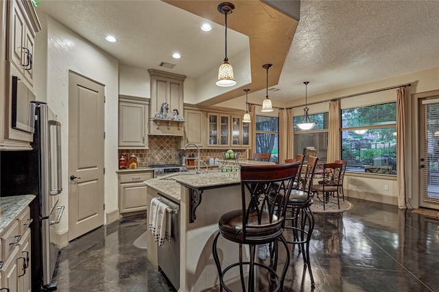 3 Creekwood Dr, Montgomery, TX 77356 - kitchen featuring tasteful backsplash, a breakfast bar, a textured ceiling, glass insert cabinets, and a kitchen island with sink