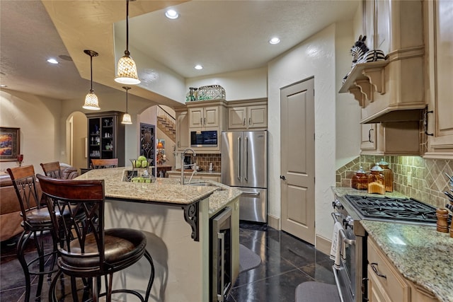 3 Creekwood Dr, Montgomery, TX 77356 - kitchen featuring stainless steel appliances, arched walkways, a breakfast bar, wine cooler, and light stone countertops
