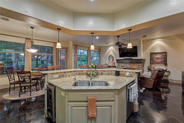 3 Creekwood Dr, Montgomery, TX 77356 - kitchen featuring beverage cooler, open floor plan, ceiling fan, a center island with sink, and light stone counters