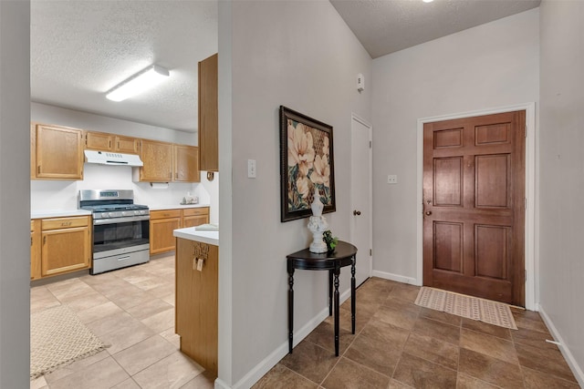 3310 Country Meadows Ct, Pearland, TX 77584 - kitchen with stainless steel range with gas stovetop, under cabinet range hood, a textured ceiling, and light countertops