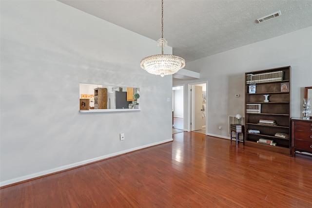 3310 Country Meadows Ct, Pearland, TX 77584 - unfurnished living room featuring a chandelier, wood finished floors, and a textured ceiling