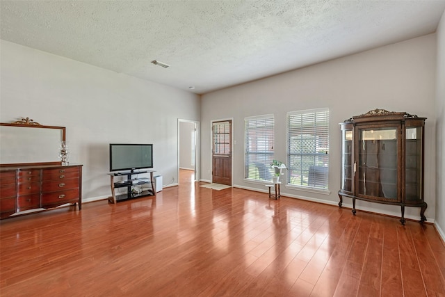 3310 Country Meadows Ct, Pearland, TX 77584 - unfurnished living room featuring wood finished floors and a textured ceiling