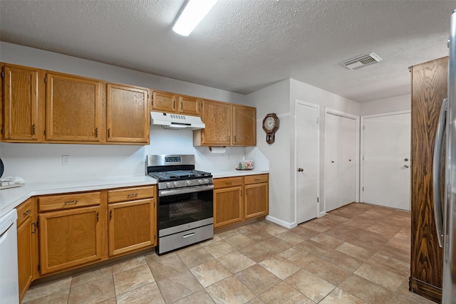 3310 Country Meadows Ct, Pearland, TX 77584 - kitchen with stainless steel appliances, under cabinet range hood, light countertops, a textured ceiling, and brown cabinets
