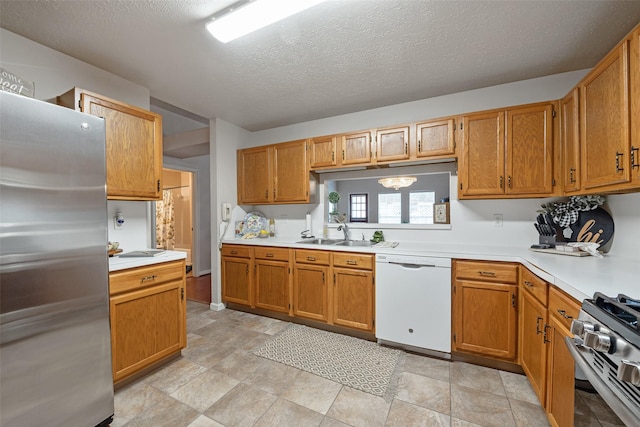 3310 Country Meadows Ct, Pearland, TX 77584 - kitchen with stainless steel appliances, light countertops, a textured ceiling, and brown cabinetry