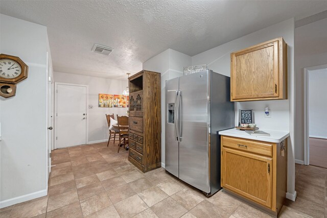3310 Country Meadows Ct, Pearland, TX 77584 - kitchen with stainless steel refrigerator with ice dispenser, light countertops, and a textured ceiling