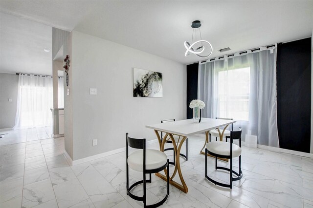12102 Benmore Dr, Houston, TX 77099 - dining area with light marble finish flooring, healthy amount of natural light, and a chandelier