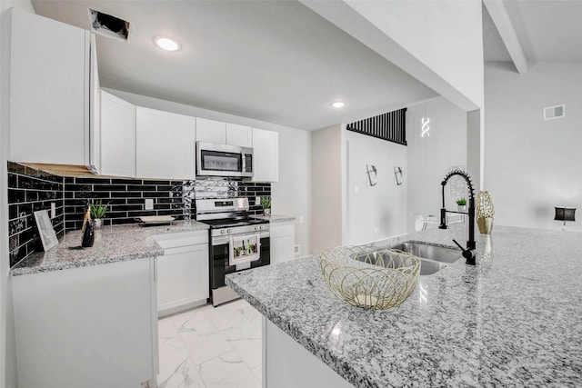 12102 Benmore Dr, Houston, TX 77099 - kitchen featuring appliances with stainless steel finishes, light marble finish floors, light stone counters, white cabinetry, and decorative backsplash