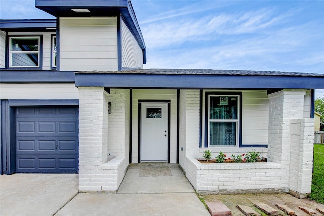 12102 Benmore Dr, Houston, TX 77099 - view of exterior entry with an attached garage, brick siding, concrete driveway, and a porch