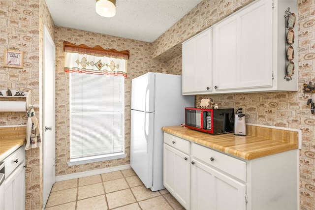 4818 Lost Lake Ln, Spring, TX 77388 - kitchen with wallpapered walls, white cabinetry, light countertops, light tile patterned flooring, and a textured ceiling