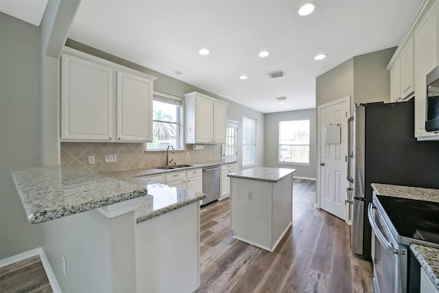 21326 Pebble Pine Trl, Cypress, TX 77433 - kitchen featuring dishwasher, electric range, a center island, a peninsula, and wood finished floors