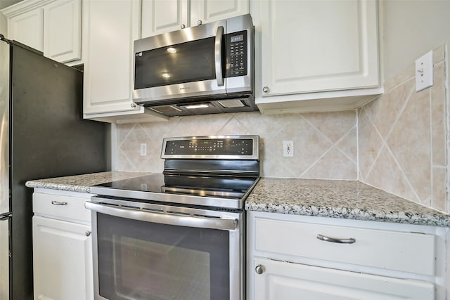 21326 Pebble Pine Trl, Cypress, TX 77433 - kitchen featuring appliances with stainless steel finishes, decorative backsplash, white cabinetry, and light stone counters