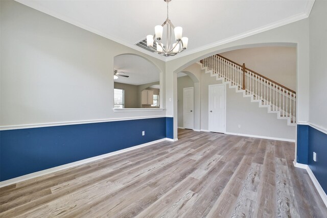 21326 Pebble Pine Trl, Cypress, TX 77433 - spare room featuring a chandelier, wood finished floors, arched walkways, crown molding, and stairs