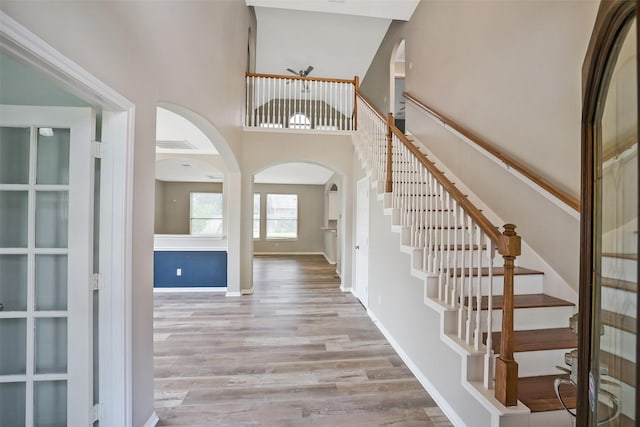 21326 Pebble Pine Trl, Cypress, TX 77433 - entryway featuring arched walkways, wood finished floors, a high ceiling, and stairway