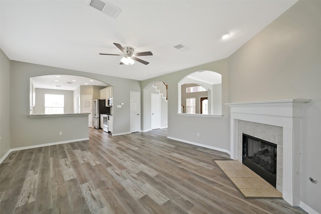 21326 Pebble Pine Trl, Cypress, TX 77433 - unfurnished living room with a ceiling fan, wood finished floors, and a tile fireplace
