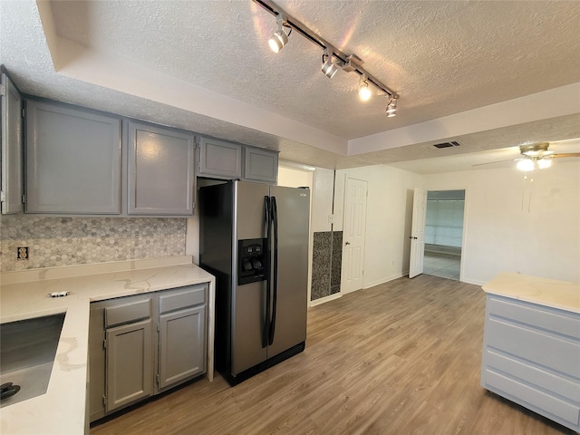 13930 New Village Ln, Sugar Land, TX 77498 - kitchen with stainless steel refrigerator with ice dispenser, a textured ceiling, gray cabinetry, light wood finished floors, and rail lighting
