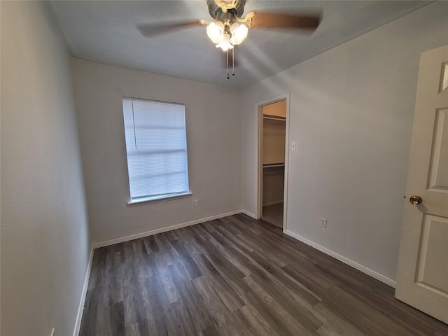 13930 New Village Ln, Sugar Land, TX 77498 - unfurnished bedroom featuring dark wood-style flooring, a walk in closet, a ceiling fan, and a closet