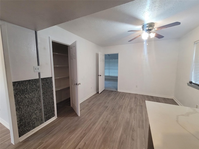 13930 New Village Ln, Sugar Land, TX 77498 - unfurnished bedroom featuring wood finished floors, a textured ceiling, and a ceiling fan