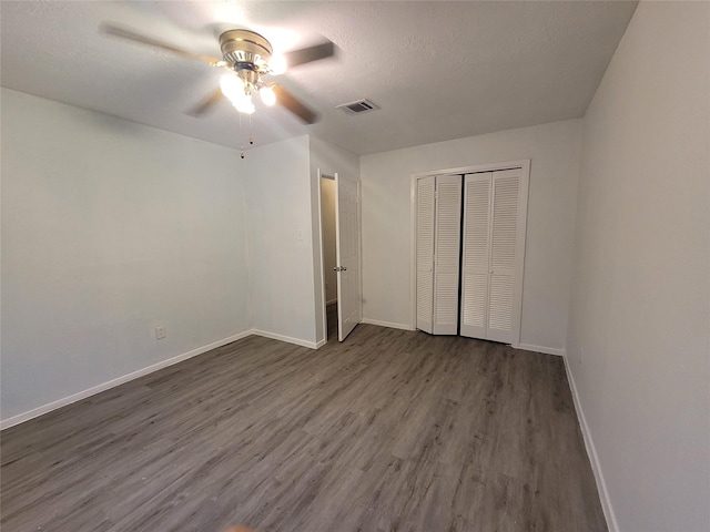 13930 New Village Ln, Sugar Land, TX 77498 - unfurnished bedroom with dark wood-type flooring, a closet, a ceiling fan, and a textured ceiling