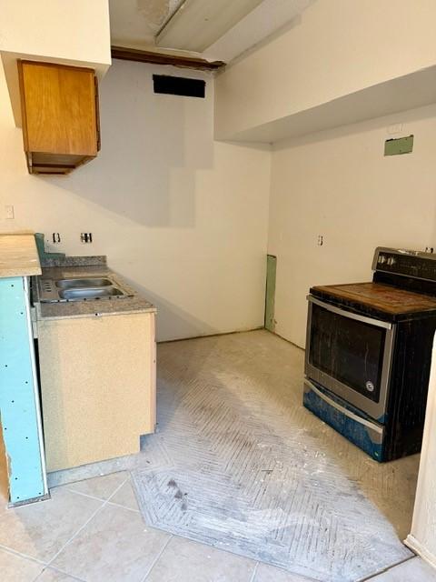 10855 Meadowglen Ln Unit 904, Houston, TX 77042 - kitchen featuring electric range, light countertops, brown cabinetry, and light tile patterned floors