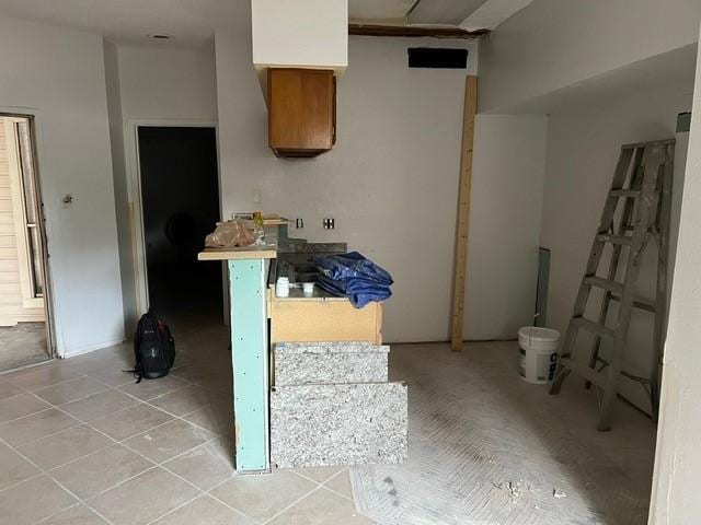 10855 Meadowglen Ln Unit 904, Houston, TX 77042 - kitchen featuring light tile patterned flooring and brown cabinetry