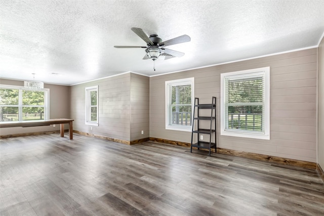 456 Cheatham Rd, Huffman, TX 77336 - unfurnished living room with a textured ceiling, wood finished floors, a ceiling fan, a chandelier, and wooden walls
