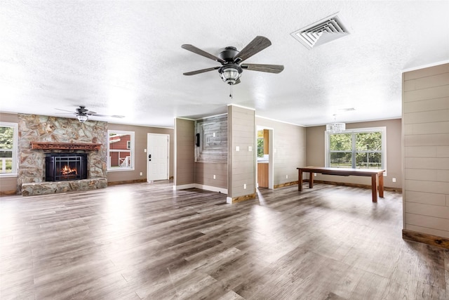 456 Cheatham Rd, Huffman, TX 77336 - living area with ceiling fan, a textured ceiling, wood finished floors, and a stone fireplace