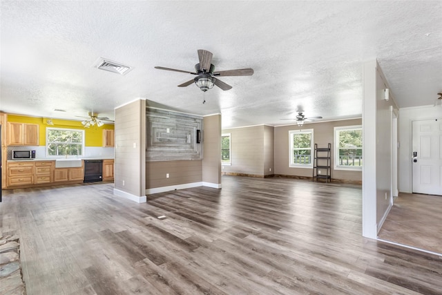 456 Cheatham Rd, Huffman, TX 77336 - unfurnished living room featuring a textured ceiling, wood finished floors, ceiling fan, healthy amount of natural light, and crown molding