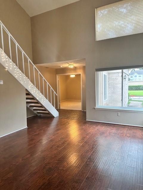 11522 Village Place Dr Unit 81, Houston, TX 77077 - unfurnished living room featuring a high ceiling, hardwood / wood-style floors, and stairway