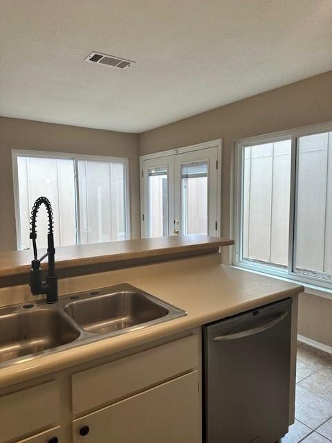 11522 Village Place Dr Unit 81, Houston, TX 77077 - kitchen featuring stainless steel dishwasher, white cabinets, light countertops, and light tile patterned flooring