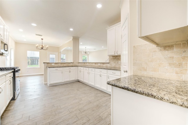4202 Maurice Way, Stafford, TX 77477 - kitchen featuring gas range oven, a chandelier, healthy amount of natural light, light stone counters, and recessed lighting