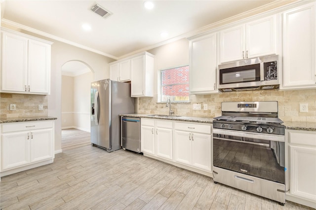4202 Maurice Way, Stafford, TX 77477 - kitchen with stainless steel appliances, backsplash, white cabinets, crown molding, and recessed lighting