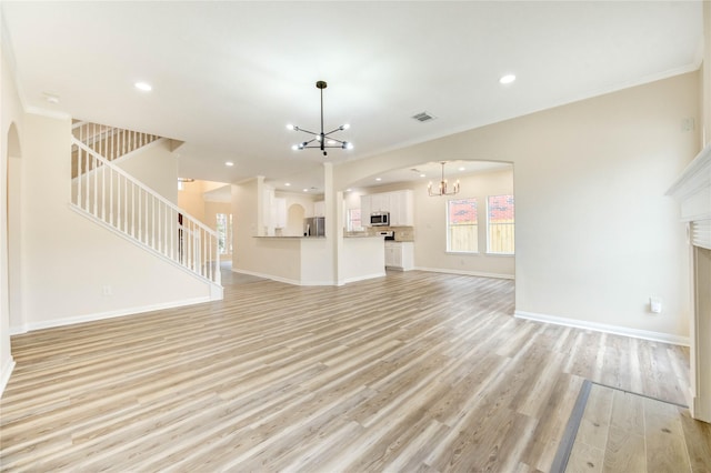 4202 Maurice Way, Stafford, TX 77477 - unfurnished living room with a chandelier, arched walkways, stairs, light wood-style flooring, and recessed lighting