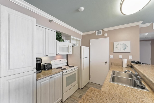 5220 Seawall Blvd Unit 1133C, Galveston, TX 77551 - kitchen with white appliances, ornamental molding, light wood finished floors, light countertops, and white cabinets