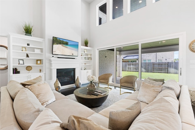 4710 Pecos Ridge Ln, Sugar Land, TX 77479 - living room featuring a high ceiling, built in shelves, and a glass covered fireplace
