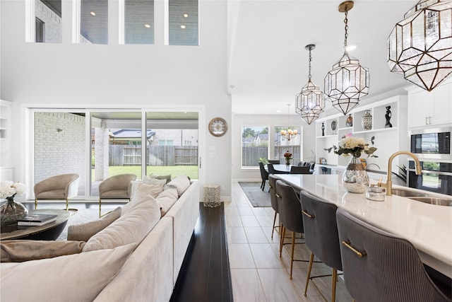 4710 Pecos Ridge Ln, Sugar Land, TX 77479 - living room with built in features, a chandelier, a towering ceiling, and light tile patterned floors