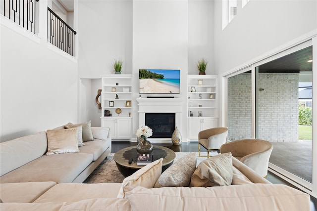 4710 Pecos Ridge Ln, Sugar Land, TX 77479 - living area with a high ceiling, a glass covered fireplace, built in shelves, and wood finished floors