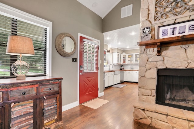 221 Kings Way, Coldspring, TX 77331 - foyer entrance featuring wood finished floors, a stone fireplace, ornamental molding, and high vaulted ceiling