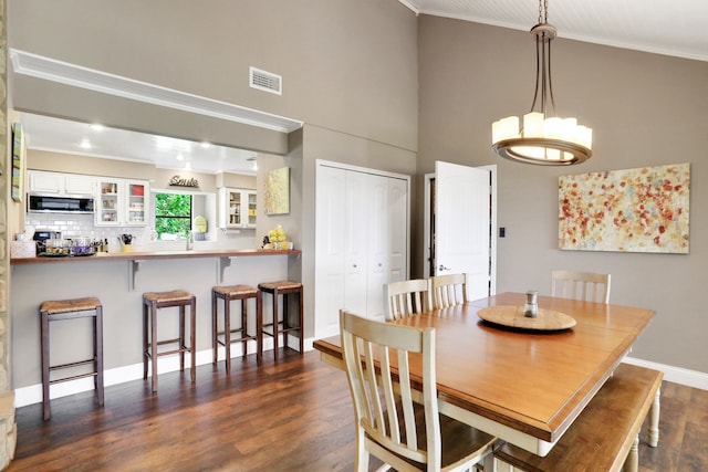 221 Kings Way, Coldspring, TX 77331 - dining room with crown molding, high vaulted ceiling, and dark wood-style flooring