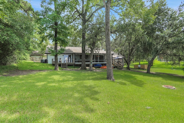 221 Kings Way, Coldspring, TX 77331 - back of house featuring a sunroom, a yard, and a deck