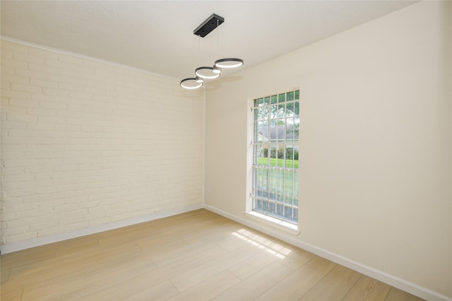 12803 High Star Dr, Houston, TX 77072 - empty room featuring light wood-style floors, brick wall, and a chandelier