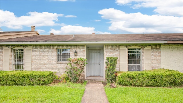 12803 High Star Dr, Houston, TX 77072 - view of exterior entry with a lawn and roof with shingles