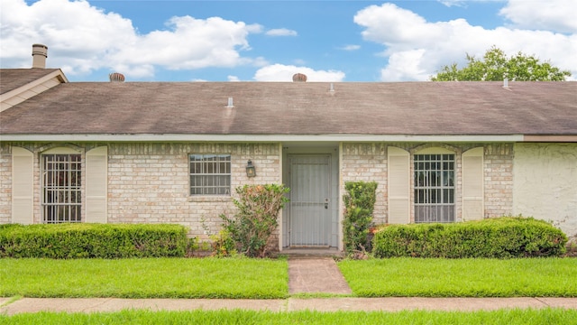 12803 High Star Dr, Houston, TX 77072 - doorway to property featuring roof with shingles, stone siding, and a yard