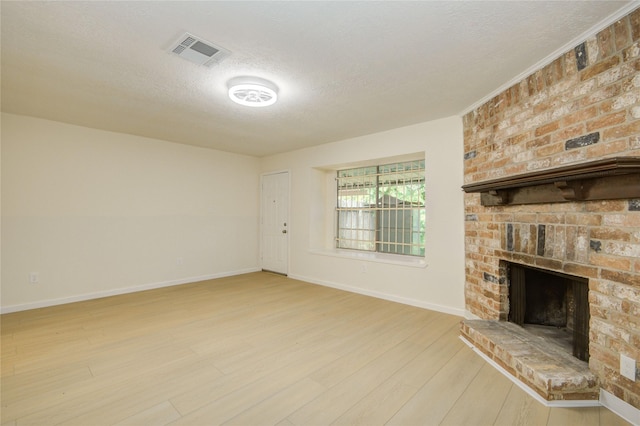 12803 High Star Dr, Houston, TX 77072 - unfurnished living room with a textured ceiling, light wood-style floors, and a fireplace