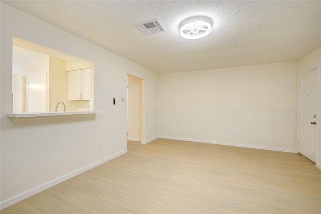 12803 High Star Dr, Houston, TX 77072 - empty room with light wood-style floors and a textured ceiling