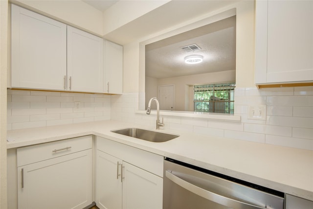 12803 High Star Dr, Houston, TX 77072 - kitchen featuring stainless steel dishwasher, decorative backsplash, white cabinetry, light countertops, and a textured ceiling
