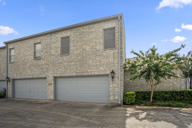 248 Wilcrest Dr Unit 248, Houston, TX 77042 - view of front of home featuring an attached garage, asphalt driveway, and brick siding