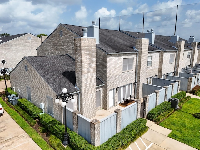 248 Wilcrest Dr Unit 248, Houston, TX 77042 - view of home's exterior featuring a chimney, brick siding, roof with shingles, and a residential view