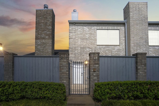 248 Wilcrest Dr Unit 248, Houston, TX 77042 - view of front facade featuring a gate and a chimney